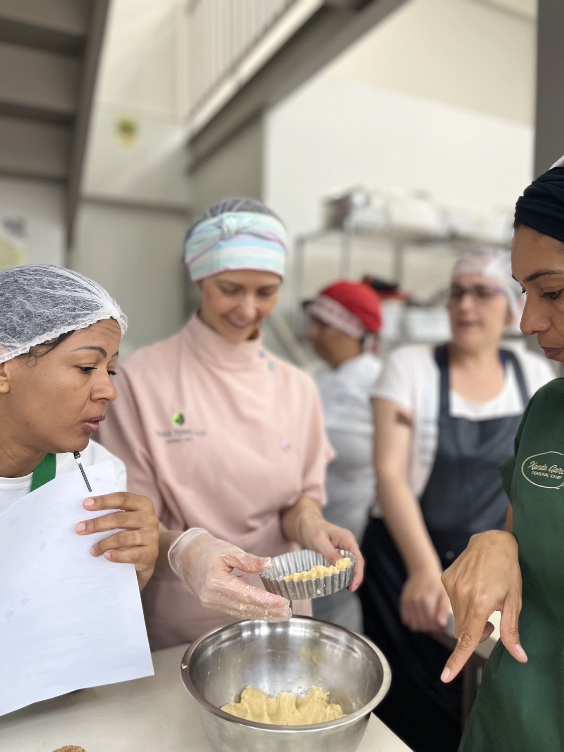 Convidadas preparando as receitas durante um evento na escola